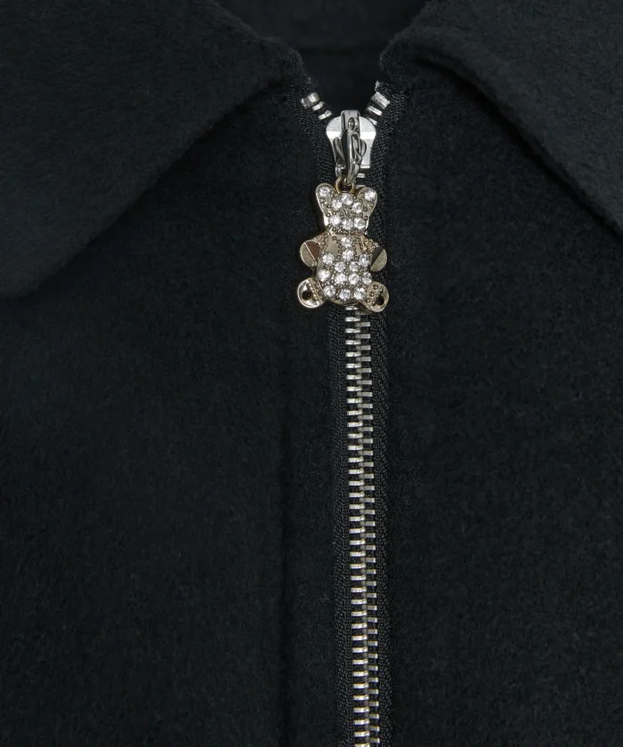 Detalle del colgante de osito en la cremallera del abrigo corto negro BSB