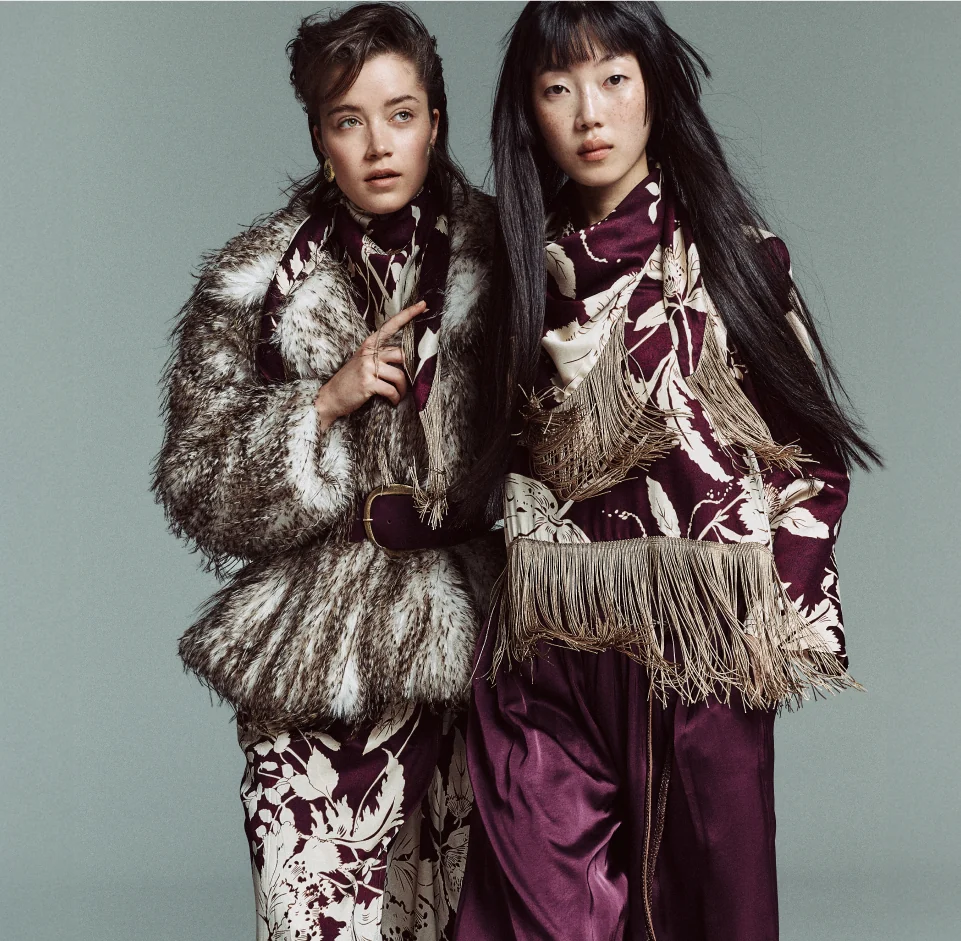 Dos modelos con abrigo de pelo y estampado floral burdeos, campaña BSB otoño invierno 26