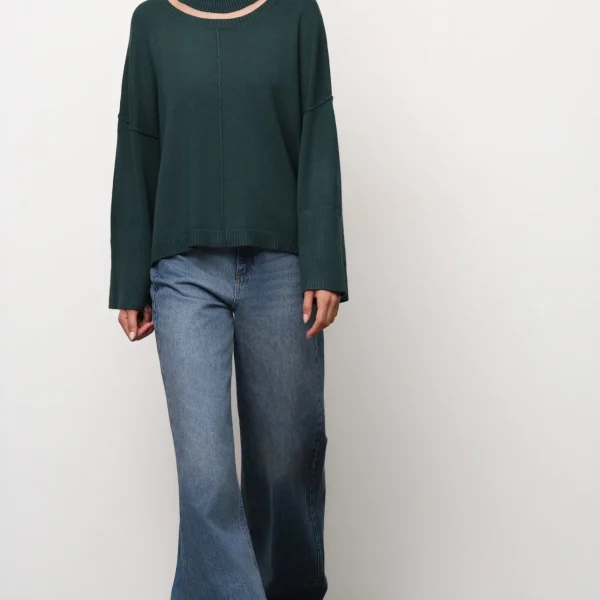 Jersey oversize de cuello alto verde oscuro BSB, de frente con vaqueros anchos