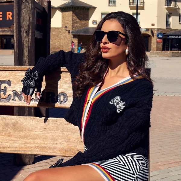 Cardigan Kaelen Camaleónica · exterior sentada Cárdigan Kaelen de Camaleónica con broche en el pecho, llevado con guantes y falda Brim.