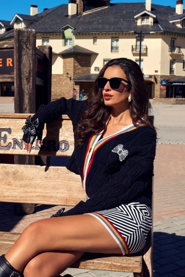 Cardigan Kaelen Camaleónica · exterior sentada Cárdigan Kaelen de Camaleónica con broche en el pecho, llevado con guantes y falda Brim.