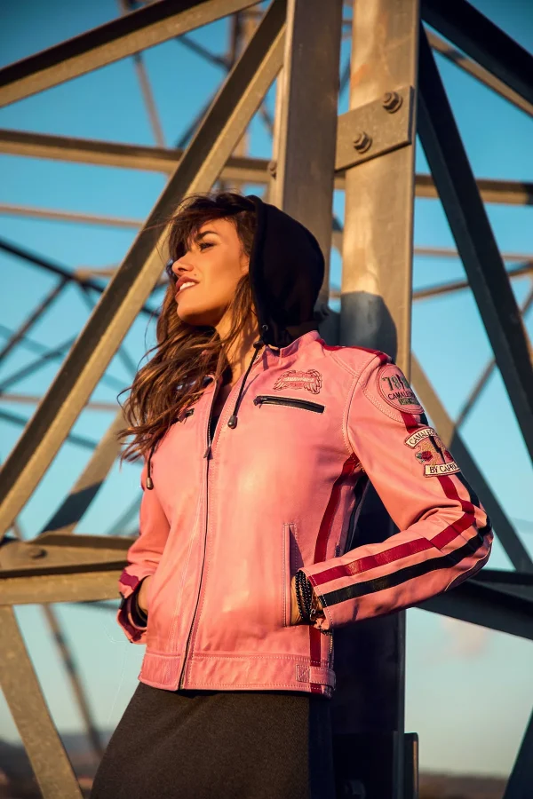 Chaqueta Runak Camaleónica · exterior frontal Chaqueta Runak de Camaleónica de piel rosa con capucha negra, fotografiada al aire libre.