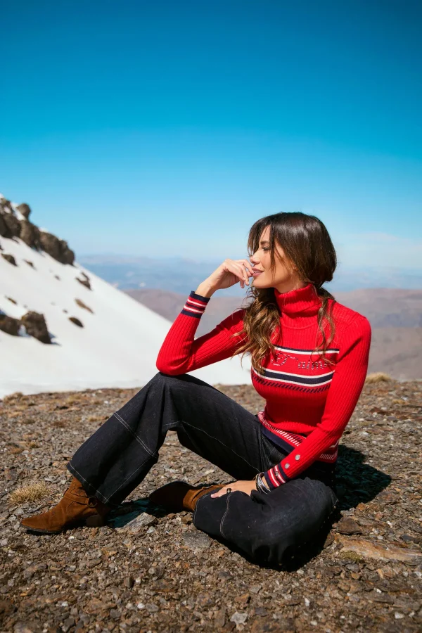 Jersey Hawklyn Camaleónica · exterior sentada Jersey Hawklyn de Camaleónica combinado con pantalón vaquero oscuro, en la montaña.